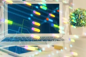 Laptop screen showing a neon data-flow diagram with labeled nodes and connecting lines on a dark grid.