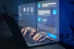 Hands typing on a laptop with translucent holographic chat UI panels and a large Send button.