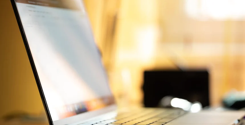 close up view of a portable computer, placed on a desk. bright, colorful and blurred background