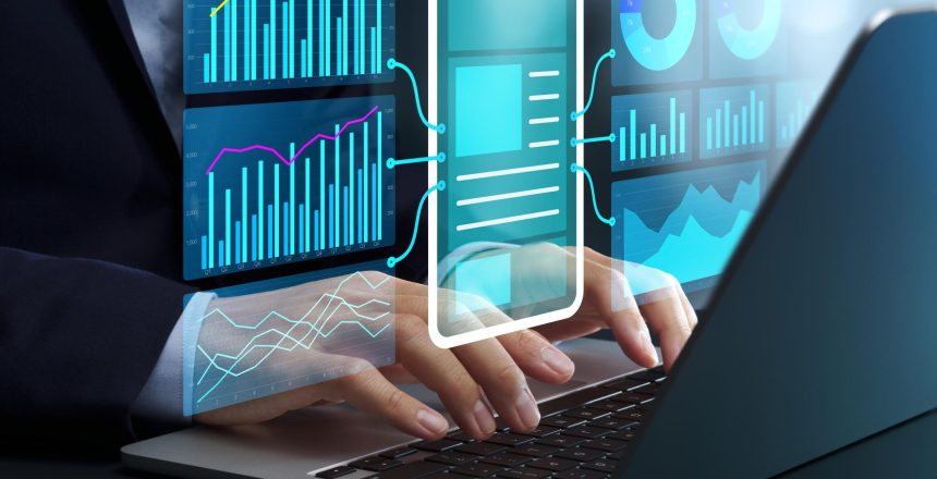 Person typing on a laptop while translucent blue data dashboards with charts float around the screen