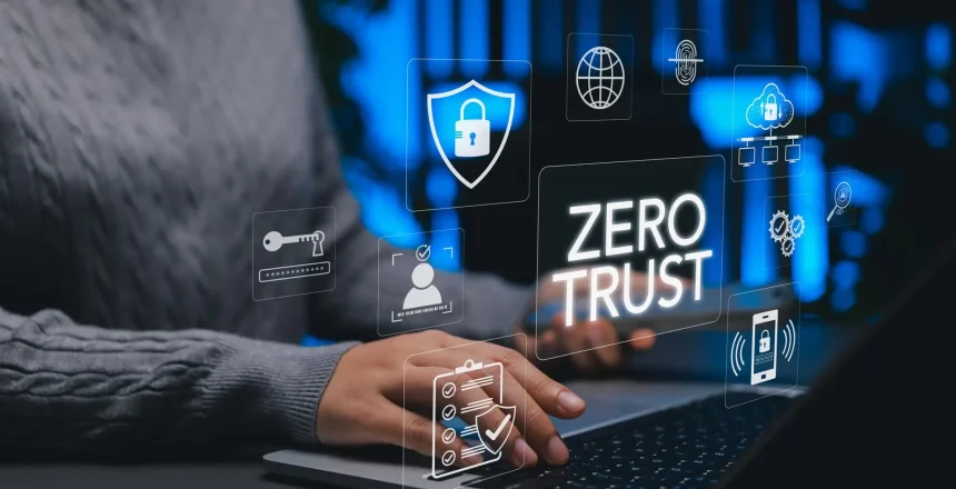 Person typing on a laptop with floating security icons and a prominent 'ZERO TRUST' label, illustrating cybersecurity.