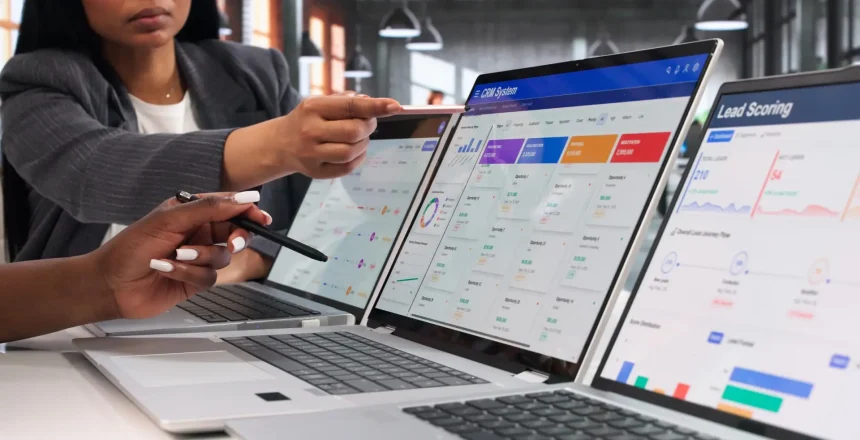 Marketing Managers Reviewing CRM Software Dashboard On Laptop For Sales Growth.