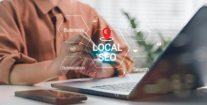 Business person working on laptop with Local SEO hologram and strategic keywords like optimization, targeting, and search, representing digital marketing and local business visibility.